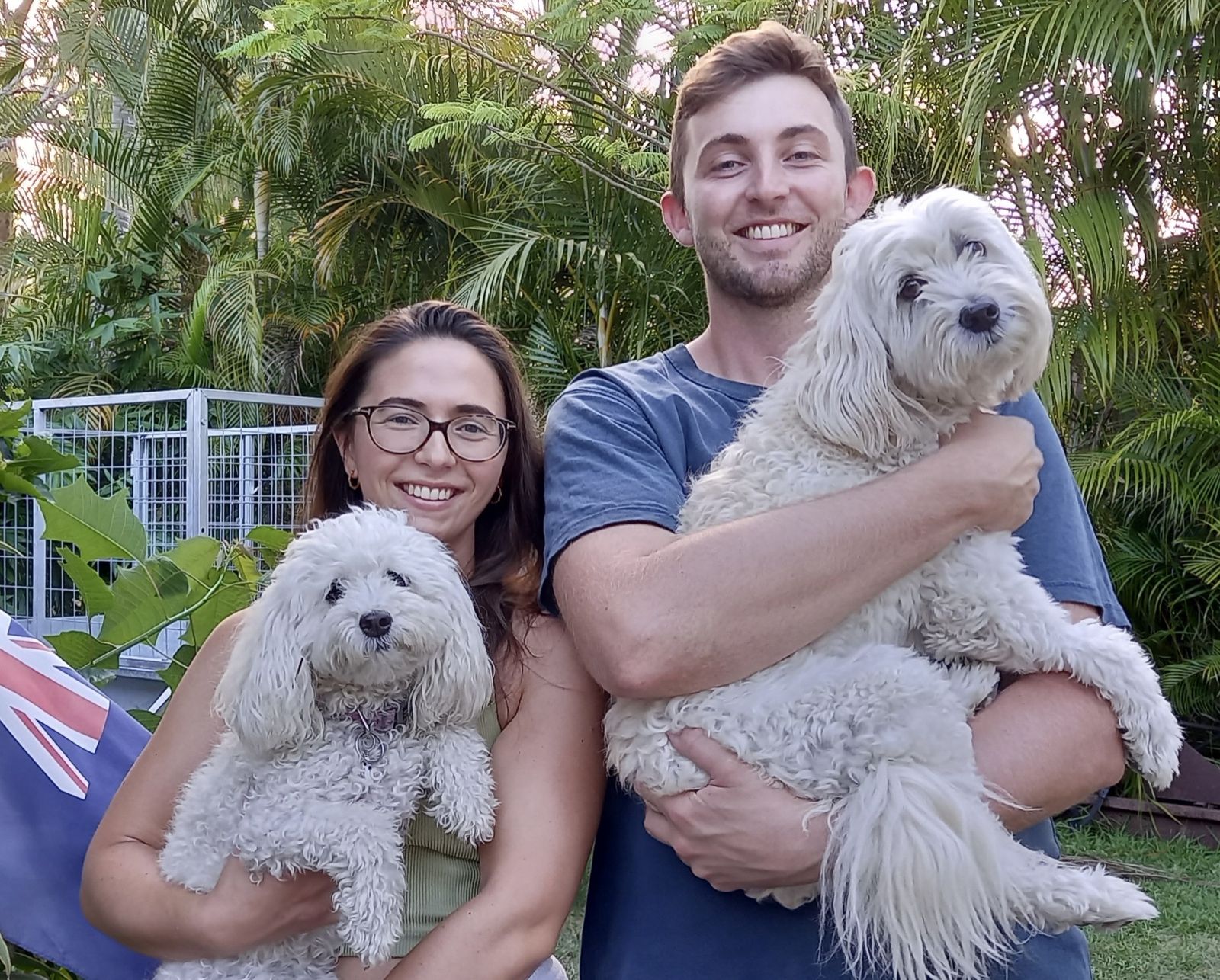 Amelia and Josh holding two fluffy white dogs